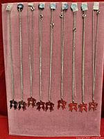 Nine pendant necklaces displayed vertically on board showing complete lot