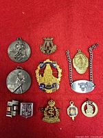 Full group of twelve medals, pins, badges and ribbon bars on red background