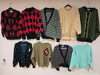 Group shot of all nine sweaters hung on wall showing styles and colours