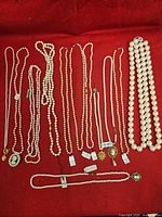 Group shot showing all necklaces and bracelet laid out on red cloth