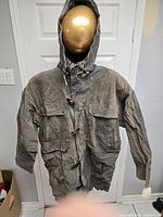 Front view of grey parka with hood displayed on mannequin