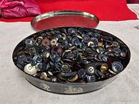 Oval metal tray full of assorted buttons