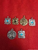 Overview of six metal pendants on red background