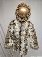Full view of hooded fur coat on mannequin