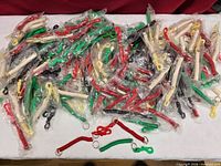 Pile of assorted colour plastic spiral wrist coil keychains, most in clear plastic bags