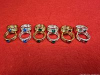 Ten rings arranged showing gold and silver finishes and stone colours