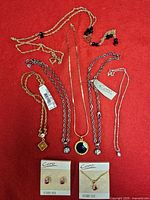 Overview of all necklaces, boxed earrings and necklace on red background