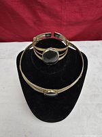 Choker necklace and cuff bracelet displayed on stand
