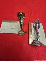 Front view of both cobra brooches on Vendome cards