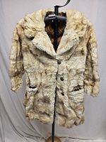 Front view of fur coat showing overall design, buttons and pockets