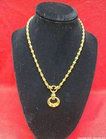 Full view of gold-plated necklace on bust form