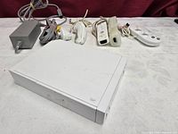 Front view of Wii console with power adapter, AV cable, remotes, Nunchuks, Classic Controller