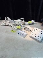 Group of extension cords and adapters showing overall lot
