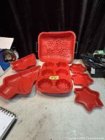 All seven red silicone baking molds displayed