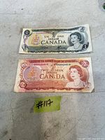 Front of both banknotes showing denominations and Queen Elizabeth II portraits