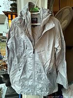Full front view of grey hooded winter jacket on hanger