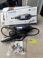 Dremel 100 rotary tool, box, sealed accessory bag visible