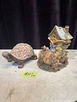 Turtle coin bank beside boot-house coin bank full view