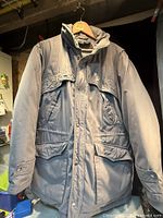 Front view of grey Down Crest winter jacket showing pockets and closure