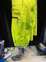 Side view of neon yellow Firefly insulated winter pants with suspenders, pockets, cuffs