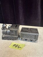 Locomotive bank connected to tender showing slot and compartment labels