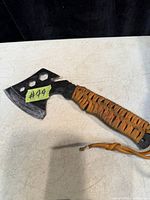 Full view of camping axe showing head design, paracord handle, and wear