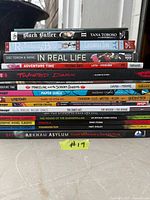 Stack of twelve young adult graphic novels and manga with spines visible