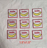 Nine square embroidered patches with smile banana design laid out on fabric