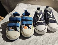 Front view of both pairs of infant Converse soft sole shoes