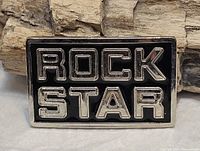 Front view displaying raised chrome "ROCK STAR" lettering on black enamel
