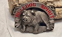 Front view of buckle showing bulldog motif and red banner text