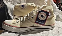 Left and right Converse Chuck Taylor All Star high-top sneakers side view with hang tag visible