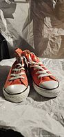 Front view of both orange Converse high-top sneakers