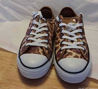 Front view of both sequined giraffe-print Converse sneakers