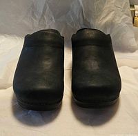 Front view of both black Dansko clogs showing closed toes and leather finish