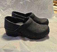 Left side view of both black Dansko clogs