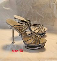 Side view of both sandals showing clear heels and silver straps