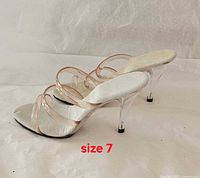 Side profile of both shoes showing clear acrylic stiletto heels and translucent straps