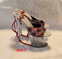 Side view of both shoes showing floral upper, clear platform, chrome heel