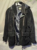 Front view of black suede leather hooded jacket on hanger