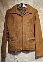 Full view of brown leather jacket hanging