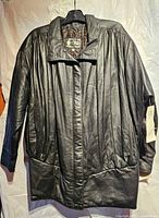 Front view of black leather jacket on hanger