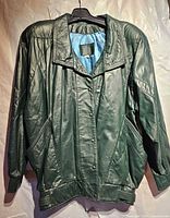 Front view of green leather jacket on hanger