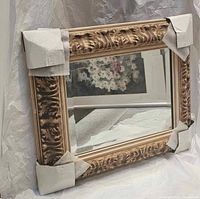 Front view showing carved wood frame and mirror glass