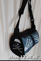 Blue barrel crossbody bag with skeleton hand and skull graphics