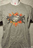 Front view of grey kids T-shirt showing Superman shield graphic and size indicator