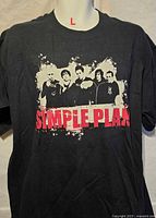 Front view of black Simple Plan size L T-shirt with band graphic