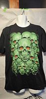 Full view of black T-shirt on mannequin showing green skull graphic