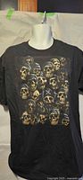 Front view of black T-shirt with multi-skull graphic