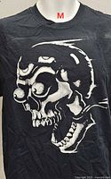 Front view of black T-shirt with white skull graphic, size label indicated as M